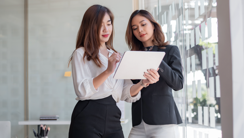 Two people looking at a tablet.