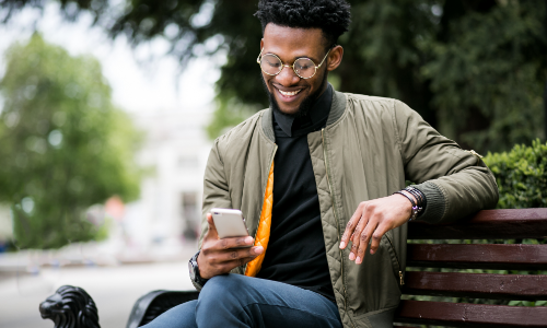Homme sur un banc avec son téléphone.