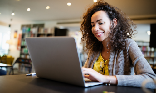 Smiling woman looking at laptop.