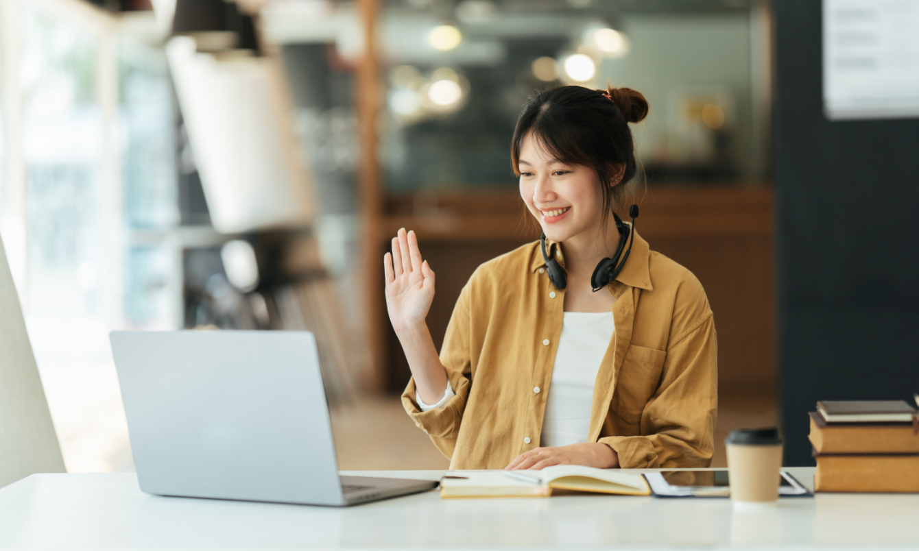 Femme faisant signe à l'ordinateur portable