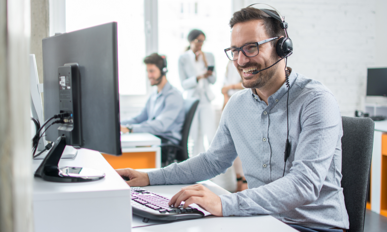 Man smiling at laptop.