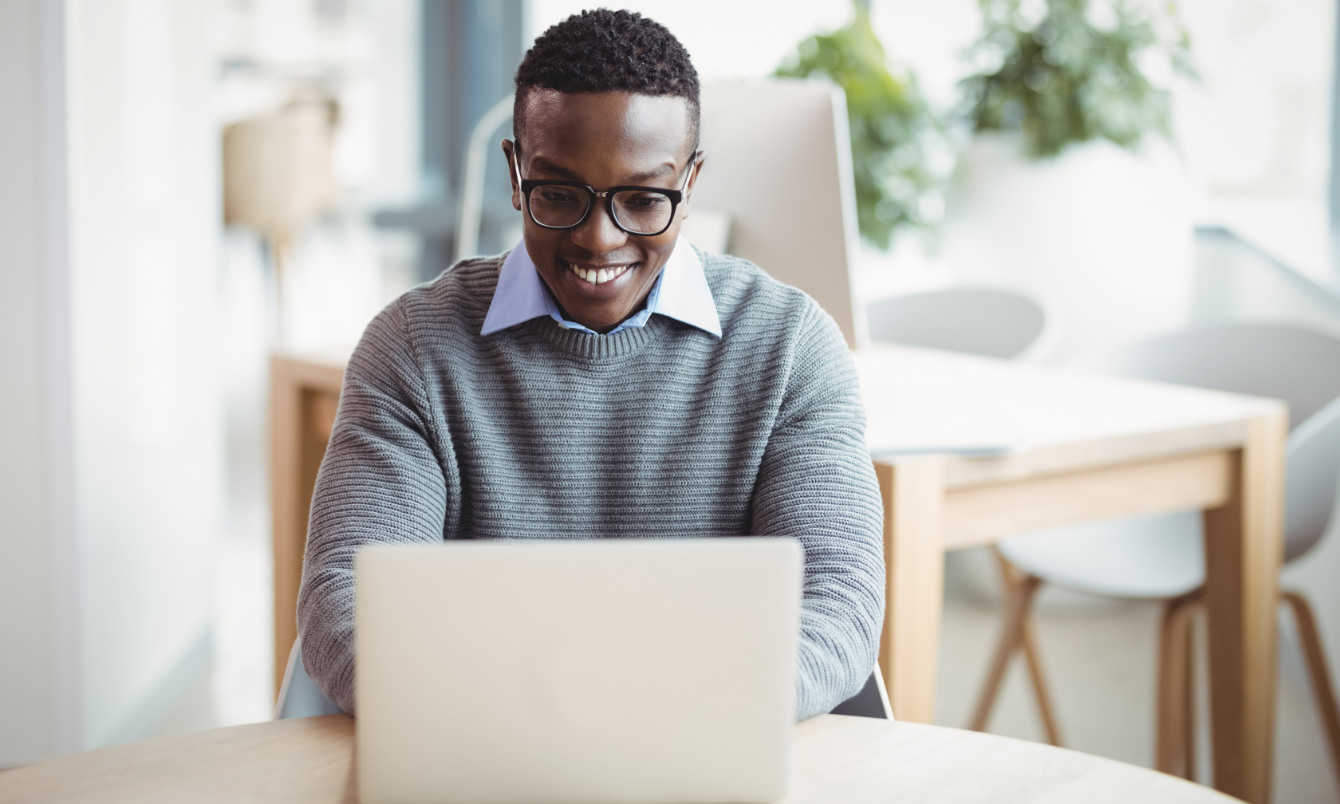 Homme souriant devant un ordinateur portable