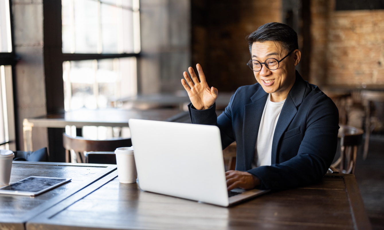 Man waving at laptop.