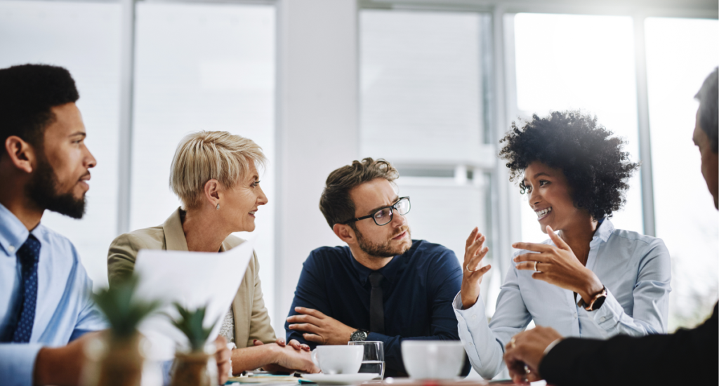 Five people in a meeting in an office room.