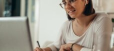 woman taking notes off of computer