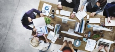 Group of people working around table.