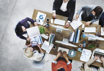 Group of people working around table.