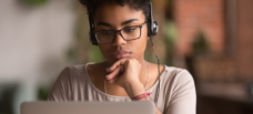 Female thinking at laptop