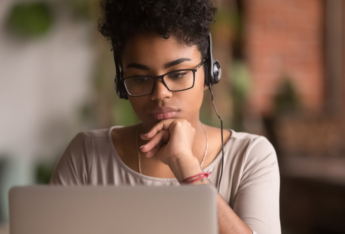Female thinking at laptop