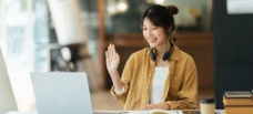 Female waving at laptop