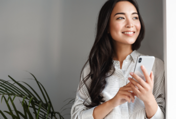 Person holding phone and looking off.
