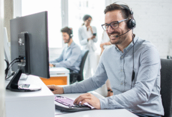 Man smiling at laptop.