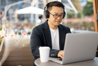 Man in headphones looking at laptop as he plans his webinar for content repurposing.