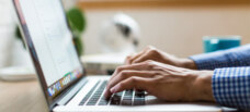Hands typing on a laptop