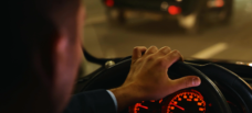 Man behind wheel of car at night.