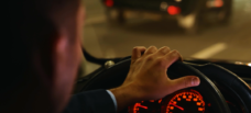 Man behind wheel of car at night time.