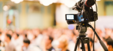 A video camera facing a crowd.