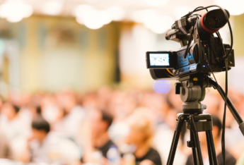 A video camera facing a crowd.