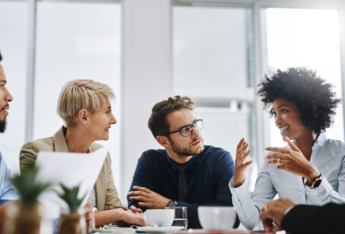 Five people in a meeting in an office room.