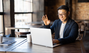 Man waving at laptop.